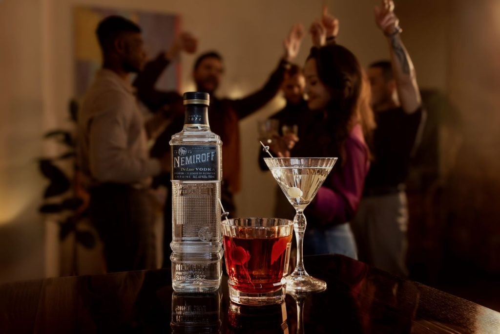 vodka bottle and glass, martini style at party, dark background.